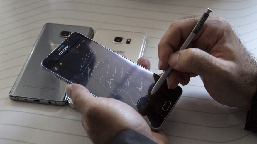 Man writes on a Samsung Galaxy Note 5 at the product